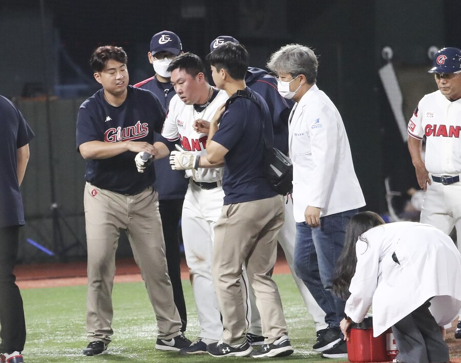 ▲ 롯데 안치홍(가운데)이 18일 사직 kt전에서 3회말 주루 도중 주심과 충돌한 뒤 부축을 받고 그라운드를 빠져나가고 있다. ⓒ연합뉴스
