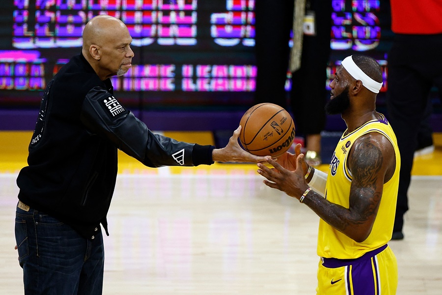 ▲ 르브론 제임스가 눈물을 훔쳤다. NBA 역대 개인통산 득점 1위에 오른 후 카림 압둘자바로부터 공을 건네 받고 있다 ⓒ 연합뉴스/AP