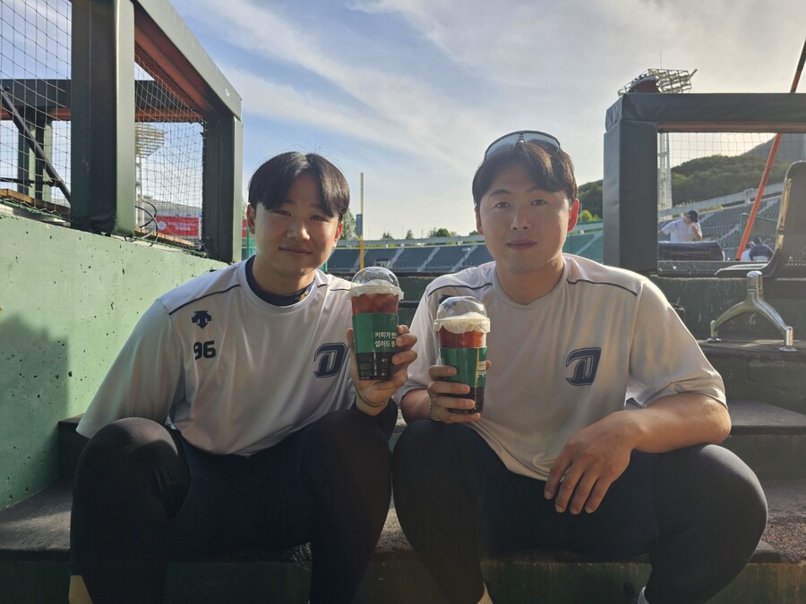 ▲ NC 페디가 전달한 커피를 마시고 있는 이준호(왼쪽)와 최성영. ⓒNC 다이노스