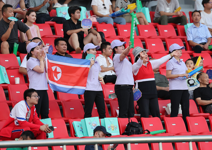 ▲ 19일 중국 항저우 진화 저장 사범대학교 경기장에서 열린 2022 항저우 아시안게임 남자축구 조별리그 F조 1차전 대만과 경기에서 인공기를 흔들며 북한을 응원하는 북한 응원단. ⓒ연합뉴스