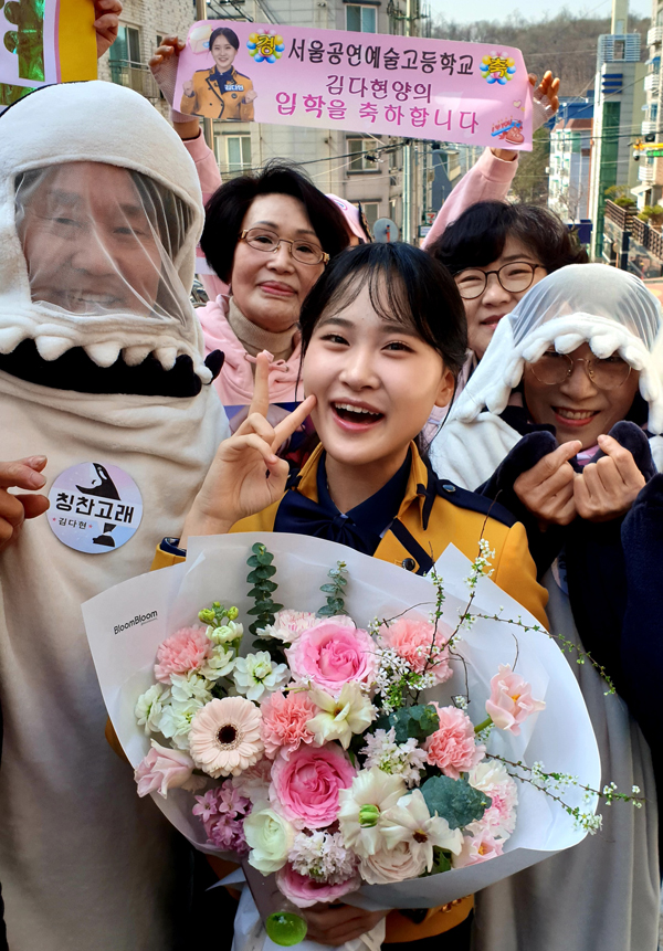 ▲ 김다현(가운데)은 4일 입학한 서울공연예술고 정문을 가득 메운 팬들에게 둘러싸여 축하 꽃다발을 받고 환한 미소를 짓고 있다. 제공|현컴퍼니