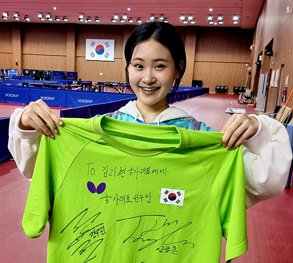 ▲ 남자탁구 국가대표 유남규 감독을 만난 김다현이 유 감독의 사인이 담긴 티셔츠를 들고 포즈를 취하고 있다. 제공|(주)현컴퍼니