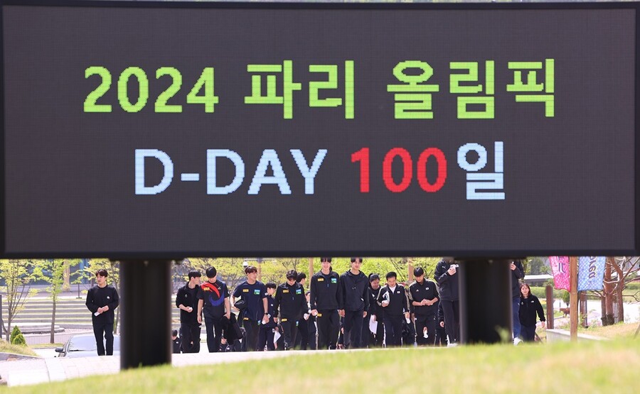 ▲ 2024 파리 하계올림픽 개막을 100일 앞둔 17일 오전 충북 진천국가대표선수촌에서 국가대표 격려 행사를 마친 선수들이 D-100 메시지가 뜬 전광판을 지나고 있다.  ⓒ 연합뉴스