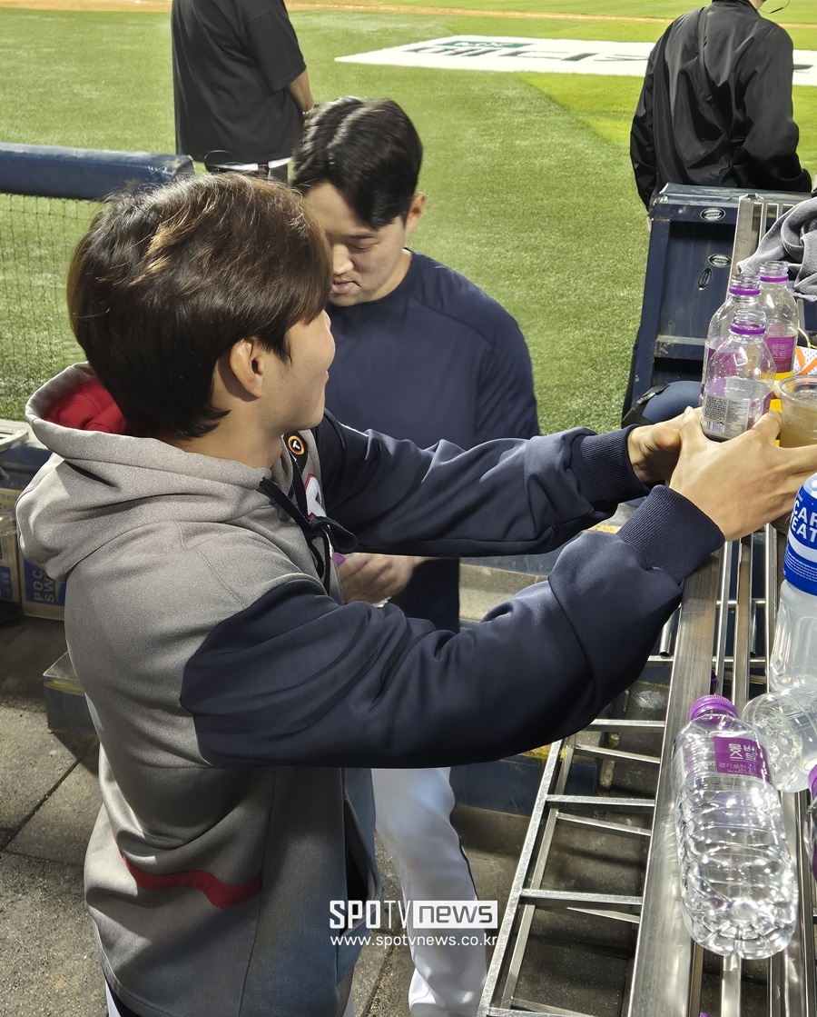 ▲ 두산 베어스 양석환과 최원준이 곽빈에게 뿌릴 물을 제조하고 있다. ⓒ 잠실, 김민경 기자
