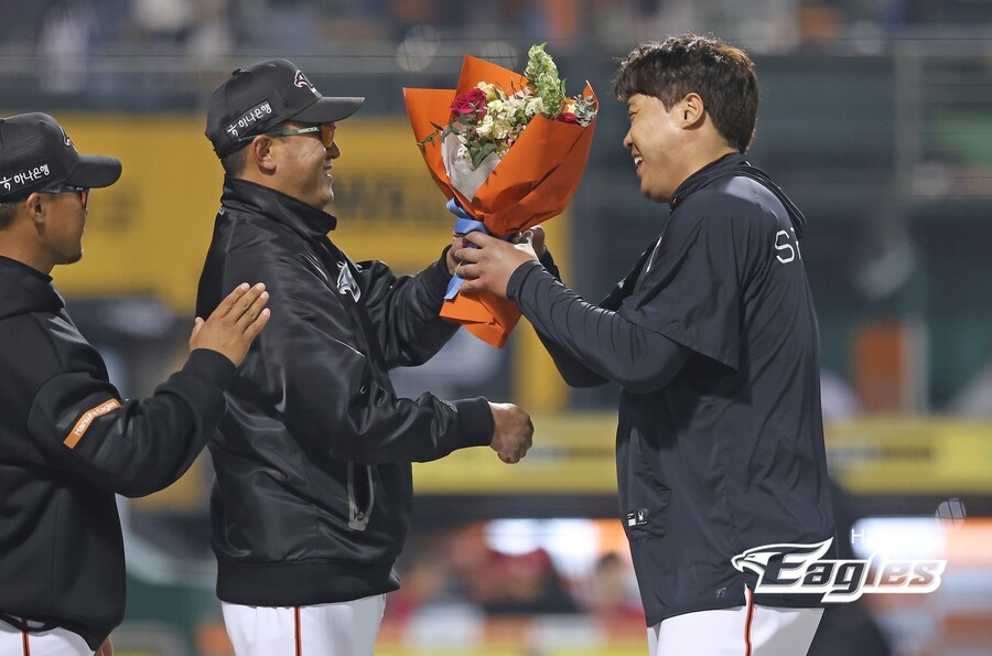 ▲ 최원호 한화 이글스 감독이 류현진의 개인 통산 100승을 축하하는 꽃다발을 전달하고 있다. ⓒ 한화 이글스