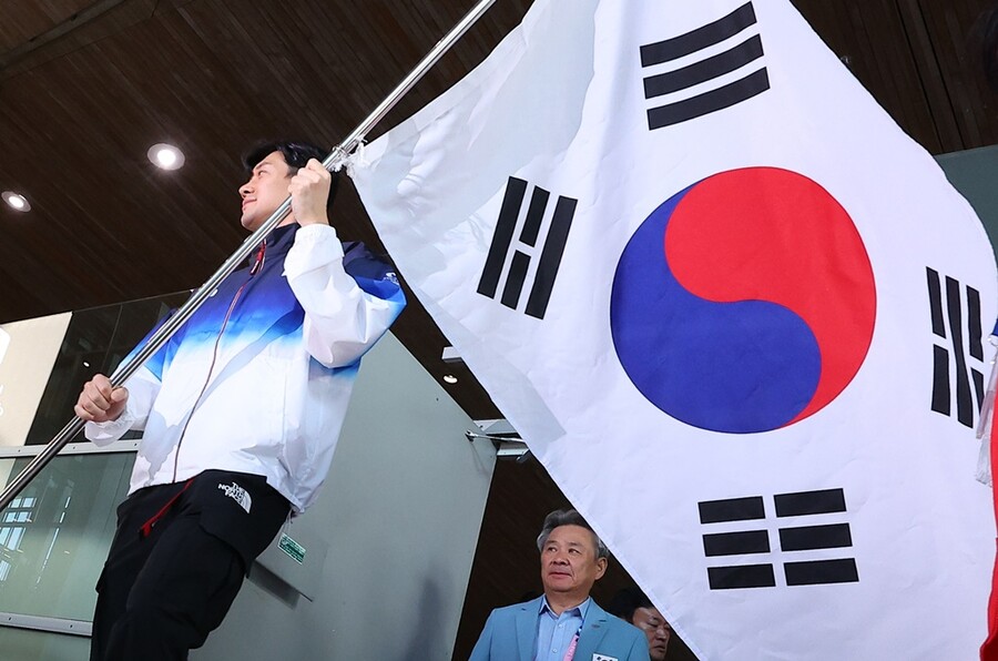 ▲ 2024 파리올림픽에 출전하는 구본길이 20일 오후(현지시간) 프랑스 파리 샤를 드골공항 2터미널에서 태극기를 흔들며 입국장에 들어서고 있다. ⓒ연합뉴스