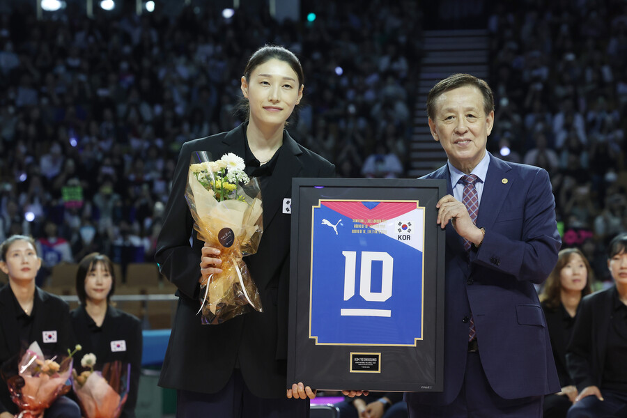 ▲ 김연경이 지난 6월 서울 잠실 실내체육관에서 열린 국가대표 은퇴식에서 기념 액자를 들고 촬영에 나서고 있다. 오른쪽은 오한남 대한배구협회장이다. 김연경은 지난 2020 도쿄올림픽 4강 신화를 이끌고 국가대표 은퇴를 선언했다. ⓒ연합뉴스