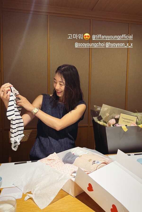 ▲ 이연희가 소녀시대 멤버들로부터 아기 옷을 선물받고 기뻐하고 있다. 출처|이연희 인스타그램