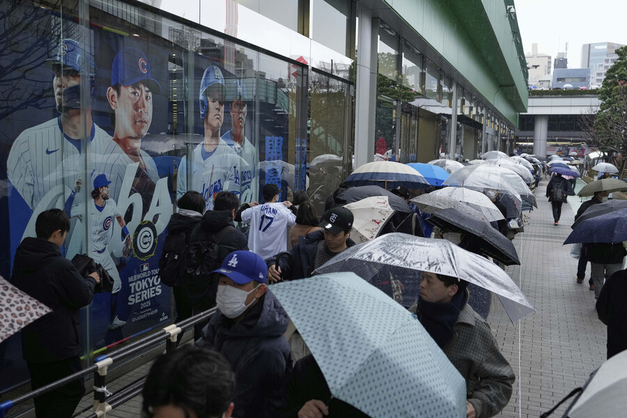 ▲ '오타니를 팝니다' 16일 비가 내리는 날씨에도 많은 일본 야구팬들이 '도쿄 시리즈 MLB 스토어' 방문을 위해 기다리는 장면. ⓒ 연합뉴스/AP