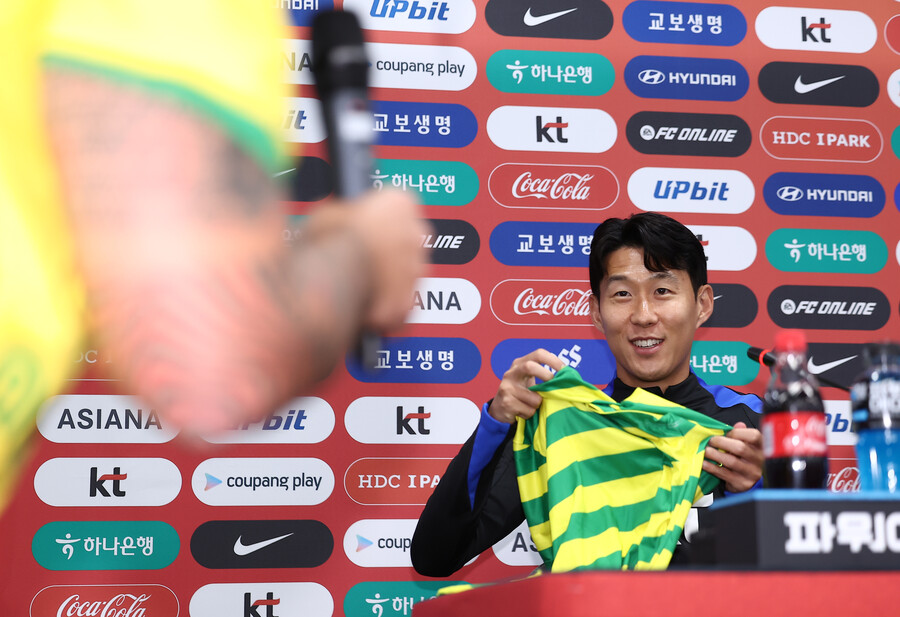 ▲ 대한민국 축구 국가대표팀 손흥민이 9일 서울월드컵경기장에서 열린 공식 기자회견에서 브라질 취재진에게 선물을 받은 뒤 기뻐하고 있다.  ⓒ연합뉴스