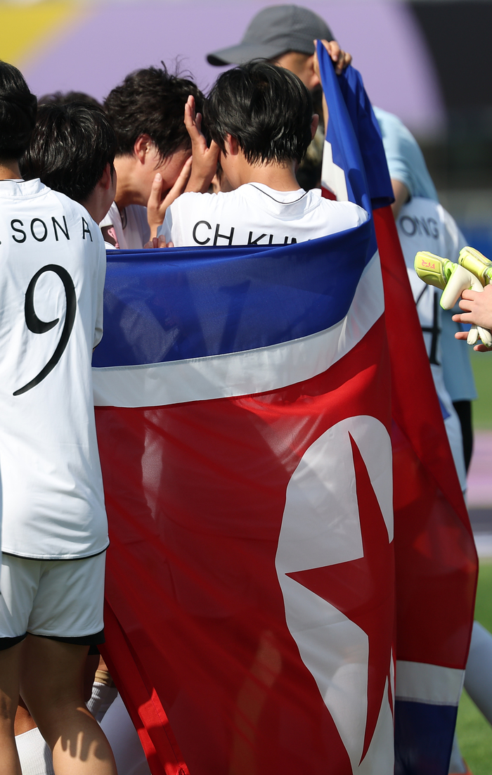 ▲ 23일 수원 장안구 수원종합운동장에서 열린 아시아축구연맹(AFC) 여자 챔피언스리그(AWCL) 결승 내고향여자축구단과 도쿄 베르디 벨레자의 경기. 내고향 선수들이 인공기를 들고 우승 기념촬영을 하고 있다.  ⓒ연합뉴스