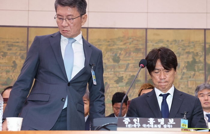 ▲ 정몽규 전 대한축구협회장(왼쪽)이 30일 국회 문화체육관광위원회에서 열린 대한축구협회 현안 관련 청문회에 증인으로 출석, 선서문을 위원장인 더불어민주당 이재정 의원에게 제출한 뒤 착석하고 있다. 정 회장 오른쪽은 홍명보 전 축구대표팀 감독.  ⓒ연합뉴스