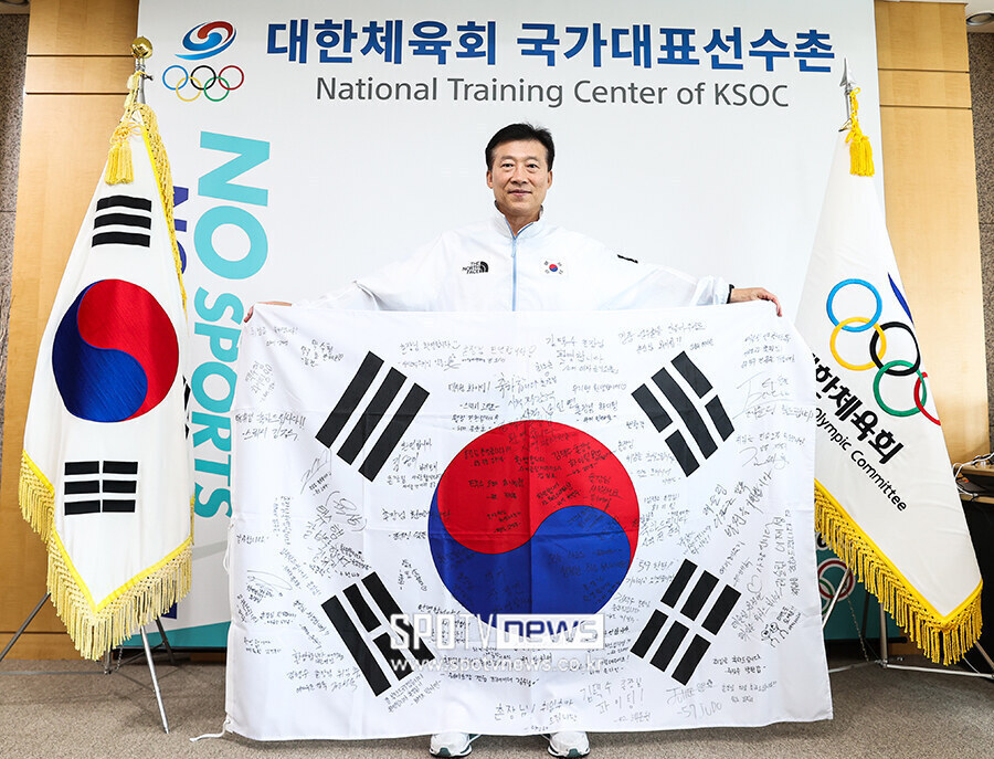 ▲ 김택수 촌장이 지난해 3월 취임한 이후 선수와 지도자들이 환영의 뜻을 담아 메시지를 남긴 대형 태극기를 펼쳐 보이고 있다. ⓒ곽혜미 기자
