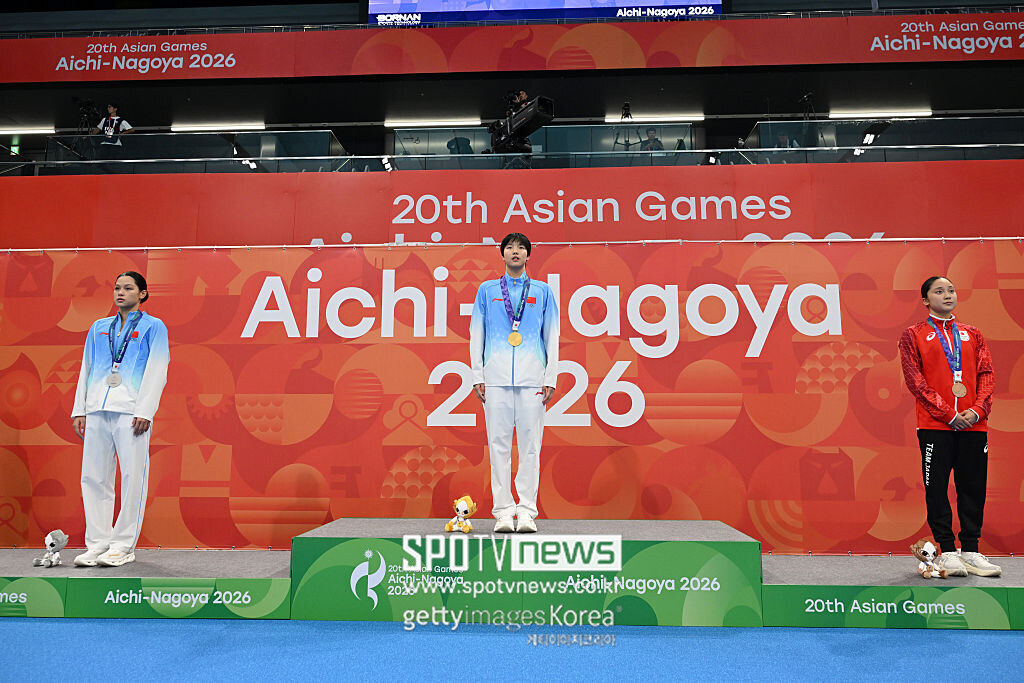 ▲ 2026년 9월 21일 일본 도쿄 아쿠아틱스 센터에서 열린 제20회 아이치·나고야 아시안게임 수영 여자 개인혼영 200m 시상식에서 금메달을 차지한 중국의 위쯔디(가운데), 은메달을 획득한 중국의 위이팅(왼쪽), 동메달을 차지한 일본의 나리타 미오(오른쪽)가 시상대에 올라 국가 연주를 듣고 있다.