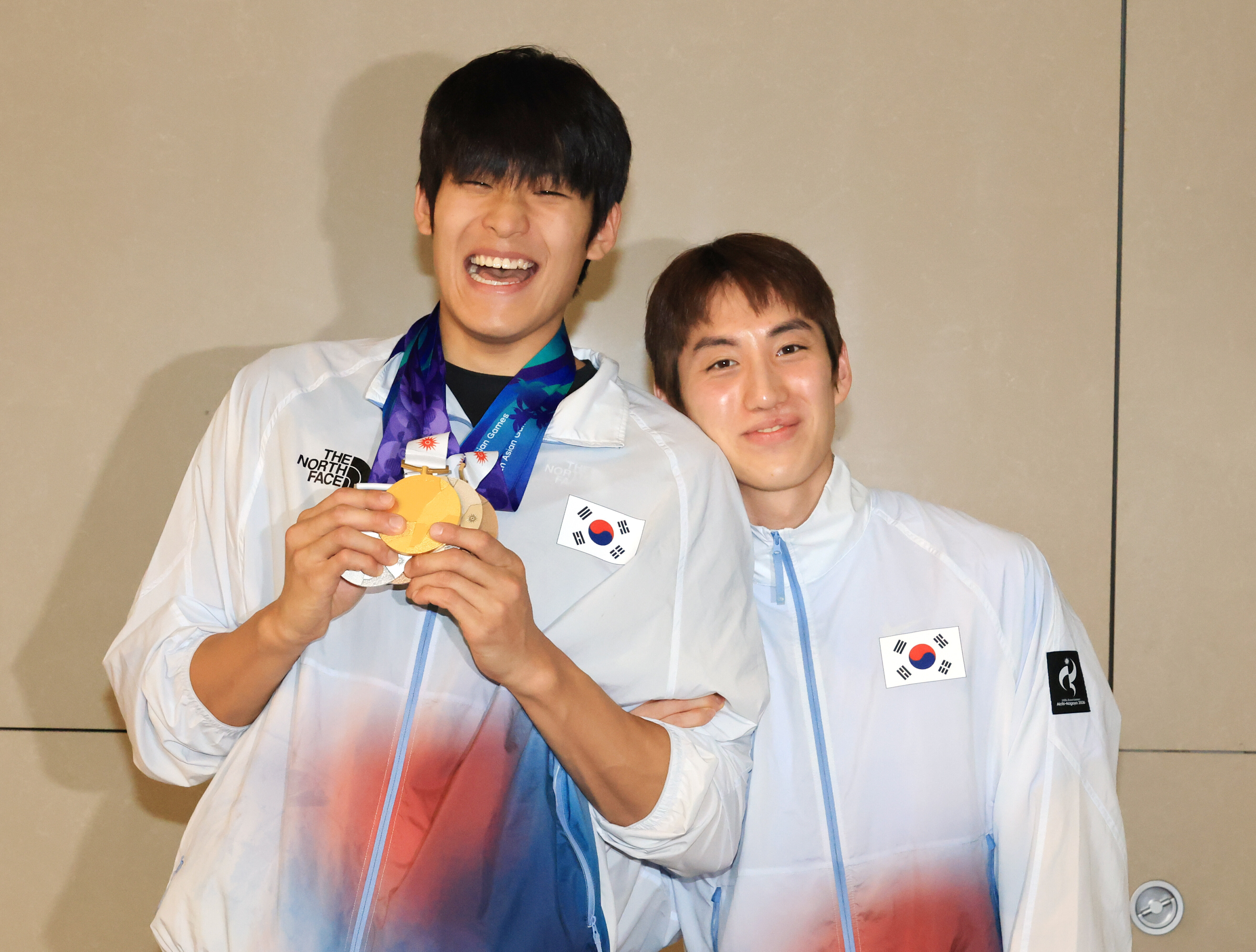 ▲ 2026 아이치·나고야 아시안게임 경영 자유형 50m에서 금메달을 획득한&nbsp;김영범이 26일 인천국제공항을 통해 귀국해 팀동료 최동열과 기념사진을 촬영하고 있다.ⓒ연합뉴스